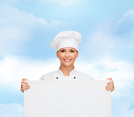 Image showing smiling female chef with white blank board