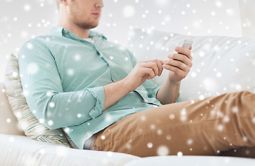 Image showing close up of man sitting with smartphone at home