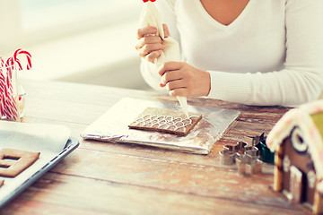 Image showing close up of woman making gingerbread houses