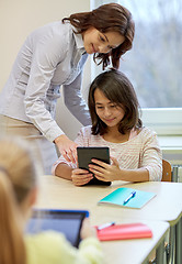 Image showing little girl with teacher and tablet pc at school