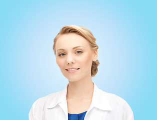 Image showing smiling young female doctor over blue background