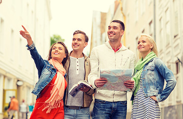 Image showing group of smiling friends with city guide and map