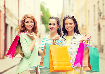 Image showing smiling teenage girls with shopping bags on street