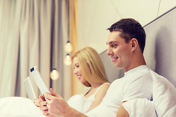 Image showing smiling couple in bed with tablet pc computers