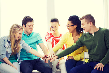 Image showing smiling students with hands on top of each other