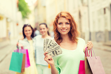 Image showing smiling teenage girls with shopping bags on street