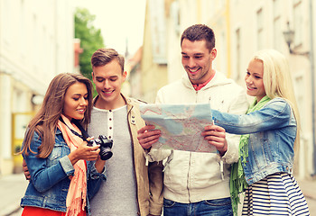 Image showing group of smiling friends with map and photocamera