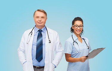 Image showing smiling doctors with clipboard and stethoscopes