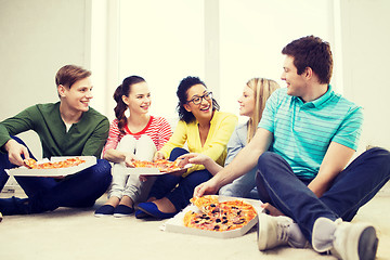 Image showing five smiling teenagers eating pizza at home