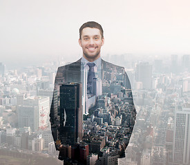 Image showing smiling young buisnessman over city background