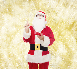 Image showing man in costume of santa claus with notepad