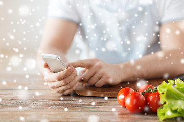 Image showing closeup of man reading recipe from smartphone