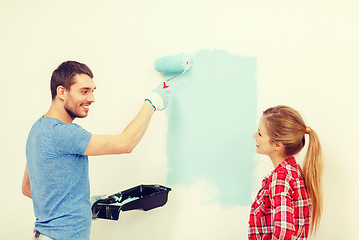 Image showing smiling couple painting wall at home