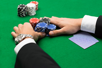 Image showing poker player with cards and chips at casino