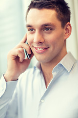 Image showing smiling businessman with smartphone in office