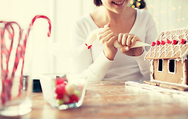 Image showing close up of woman making gingerbread houses