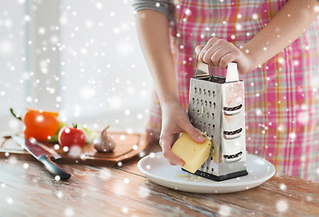 Image showing close up of woman hands with grater grating cheese
