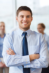 Image showing smiling businessman with colleagues in office
