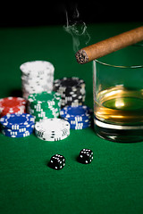 Image showing close up of chips, dice, whisky and cigar on table