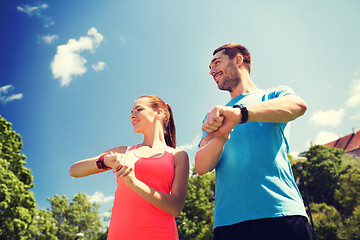 Image showing smiling people with heart rate watches outdoors