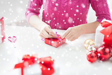 Image showing close up of woman decorating christmas presents