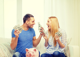 Image showing couple with money and piggybank ot table at home