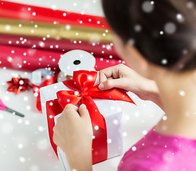 Image showing close up of woman decorating christmas present