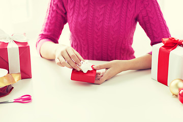 Image showing close up of woman decorating christmas presents