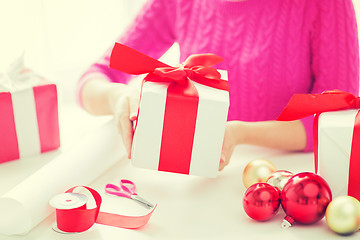 Image showing close up of woman decorating christmas presents