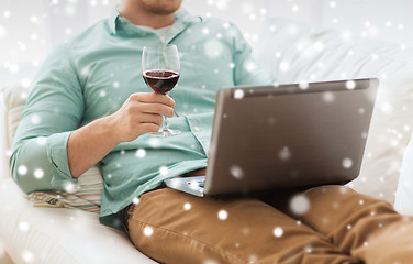 Image showing close up of man with laptop and wine glass
