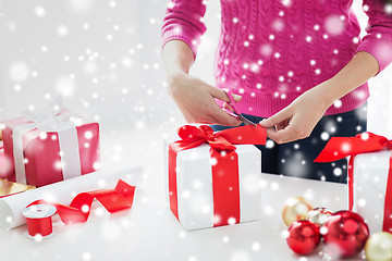 Image showing close up of woman decorating christmas presents