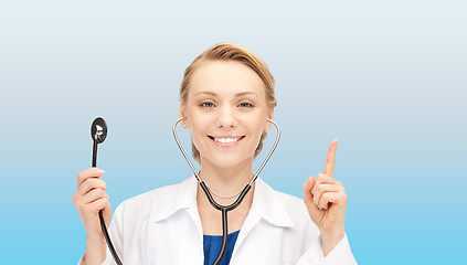 Image showing smiling young female doctor over blue background