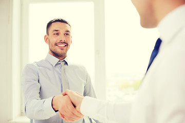 Image showing two smiling businessmen shaking hands in office