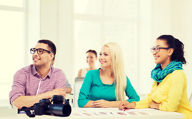 Image showing smiling team with photocamera working in office