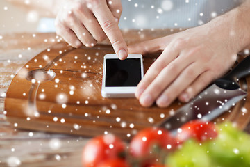 Image showing close up of man reading recipe from smartphone