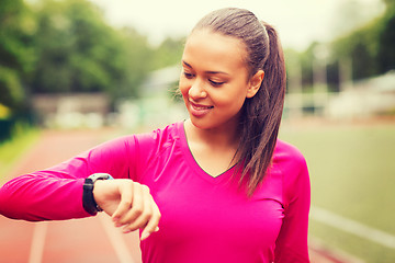 Image showing smiling woman running on track outdoors