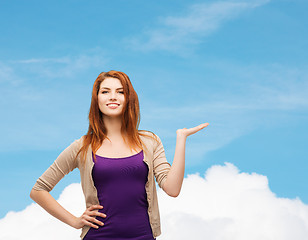 Image showing smiling teenage girl holding something on her palm