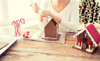 Image showing close up of woman making gingerbread houses