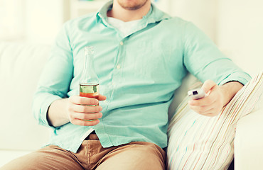 Image showing man with beer and remote control at home