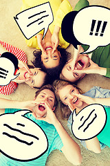 Image showing smiling people lying down on floor and screaming
