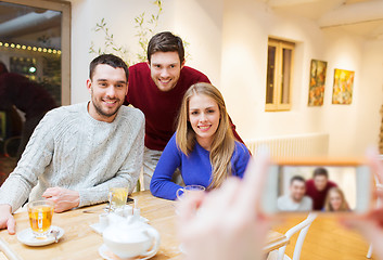 Image showing group of friends taking picture with smartphone