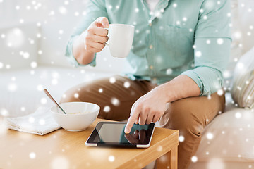 Image showing close up of man with tablet pc having breakfast