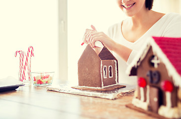 Image showing close up of woman making gingerbread houses