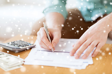 Image showing close up of man counting money and making notes