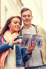 Image showing smiling couple with city guide exploring town