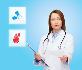 Image showing smiling doctor or nurse pointing to pills icon