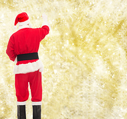 Image showing man in costume of santa claus writing something