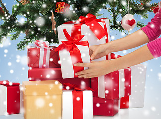 Image showing close up of woman with gifts and christmas tree