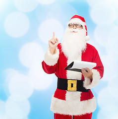 Image showing man in costume of santa claus with notepad