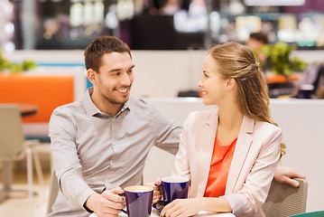 Image showing happy couple with shopping bags drinking coffee